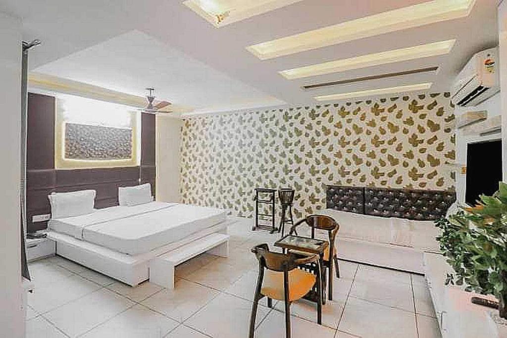 a bedroom with a bed and a table and chairs at Super OYO Hotel Vivaan Residency in Rohtak