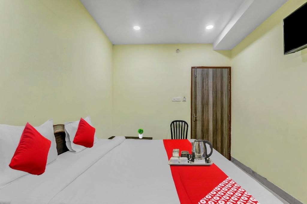 a room with a bed with red and white pillows at OYO Flagship Govind Guest House in Gorakhpur