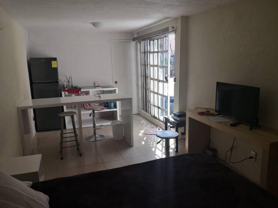 um quarto com uma cozinha e uma sala de estar com uma mesa em Loft E Metro Copilco UNAM Coyoacan- E em Cidade do México