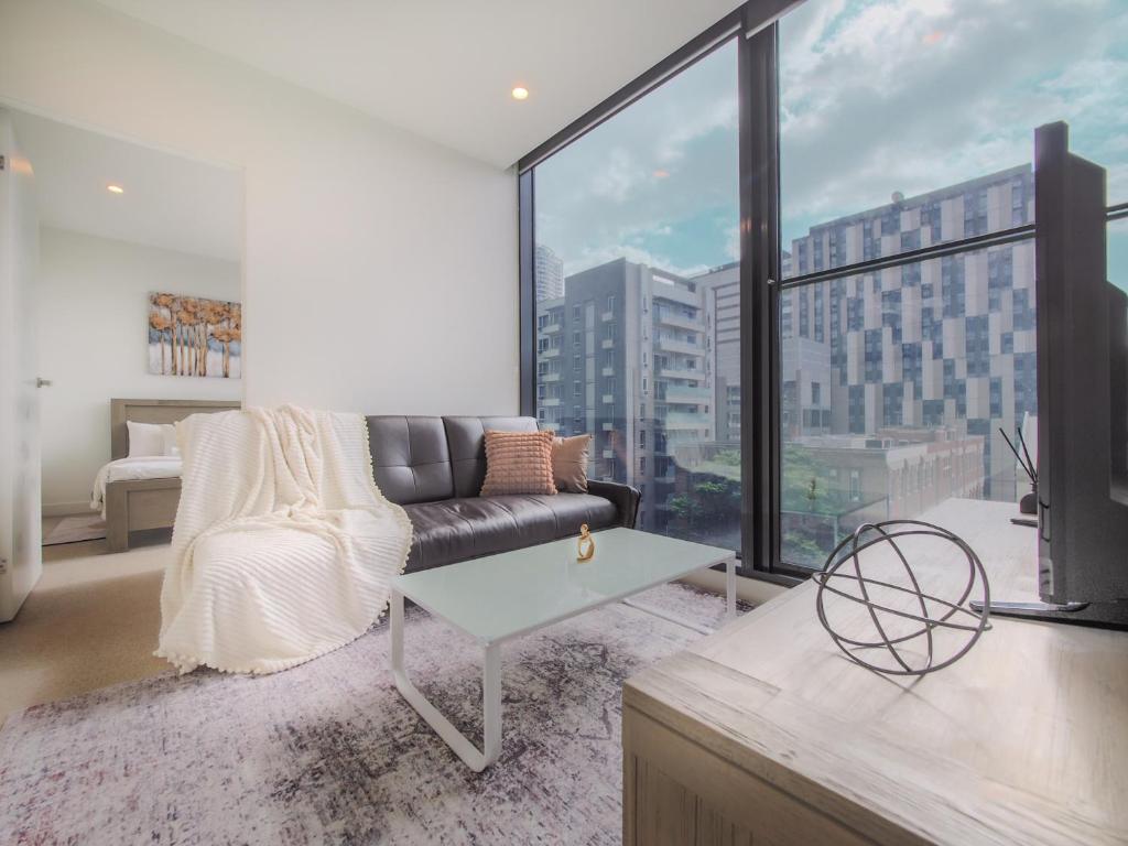 een woonkamer met een bank en een groot raam bij Delightful 1br1ba Carlton With Great Location in Melbourne