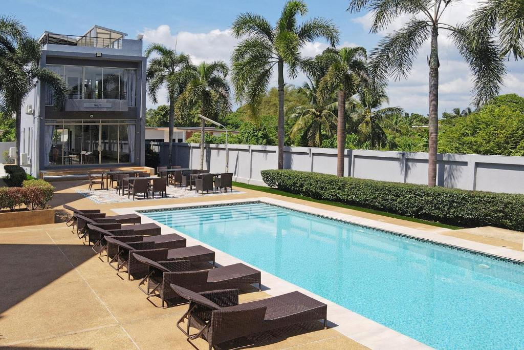 une piscine avec des chaises longues et une maison dans l'établissement Modern 3BR Pool Access Villa Argent 6, à Ban Muang Mai
