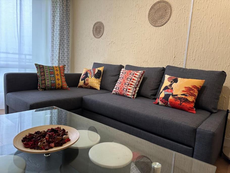 Exotic Spacious Stylish Apartment Retreat في Ris-Orangis: غرفة معيشة مع أريكة مع وسائد وطاولة
