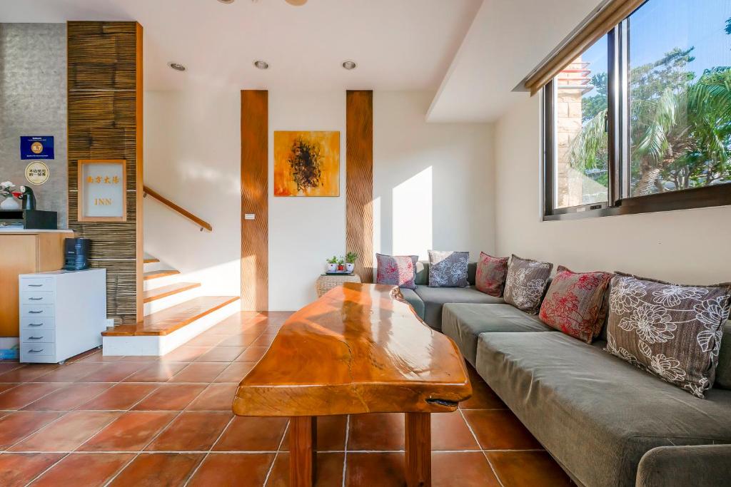 a living room with a couch and a wooden table at Southern Sun Homestay North in Kenting