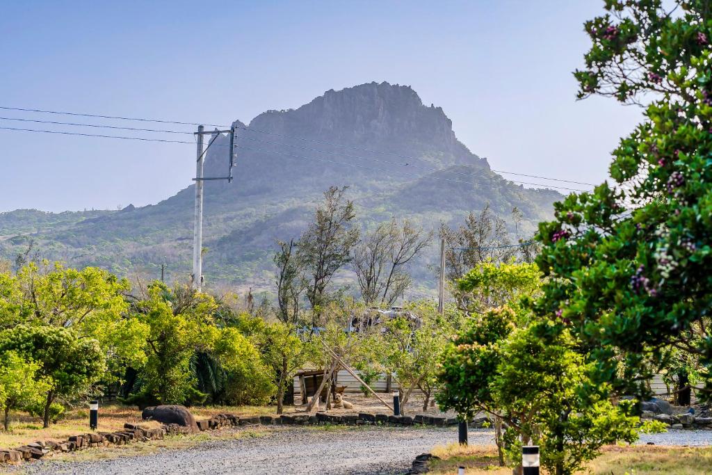 a dirt road with a mountain in the background at Southern Sun Homestay North in Kenting