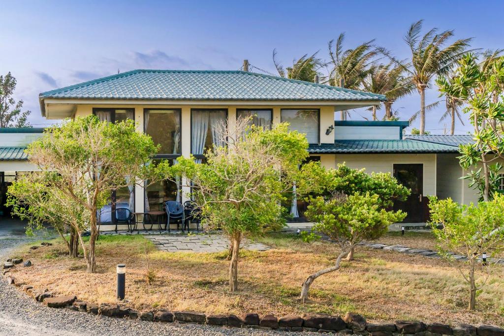 a house with trees in front of it at Southern Sun Homestay North in Kenting