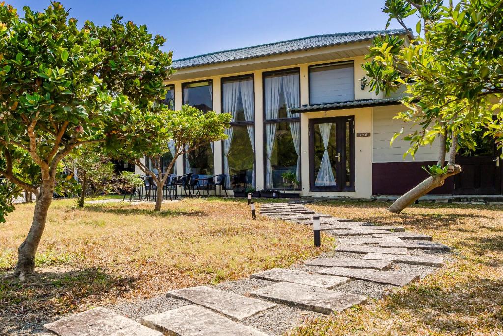a house with a stone path in front of it at Southern Sun Homestay North in Kenting