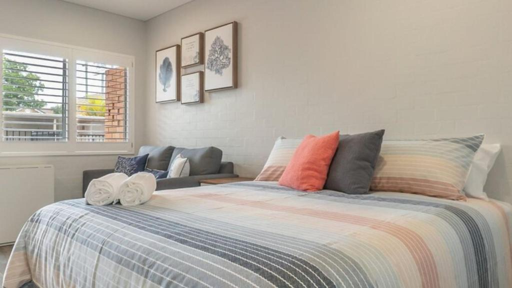 a bedroom with a large bed and a couch at Coasters 18 in Sawtell