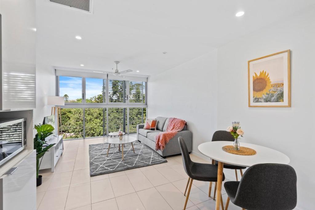 ein Wohnzimmer mit einem Sofa und einem Tisch in der Unterkunft Cozy 1 bedroom in the Heart of South Brisbane with parking in Brisbane