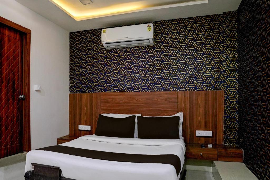 sypialnia z łóżkiem i ścianą w obiekcie OYO Hotel Angel Park w mieście Ahmadabad