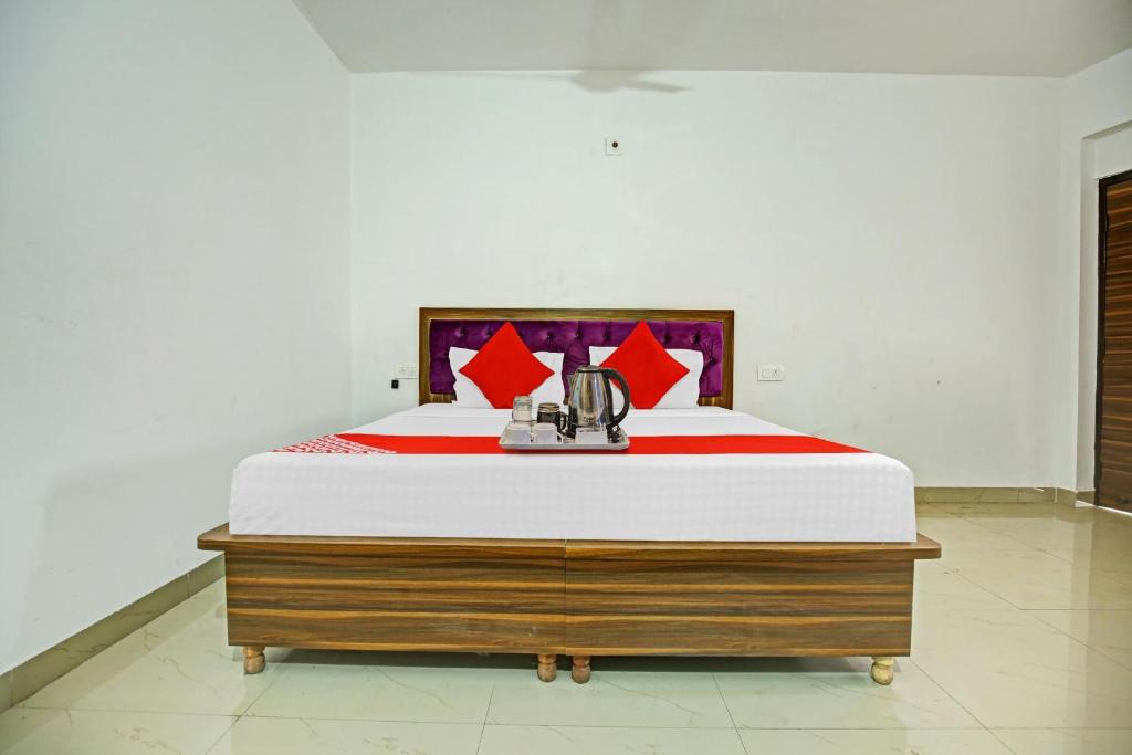 a bedroom with a large bed with red pillows at Flagship Hotel Hc Punjab Inn in Mohali