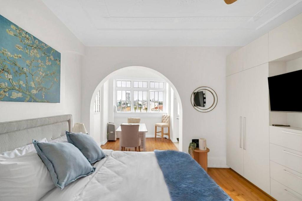 a white bedroom with a bed and a dining room at Kadina Harbourside Studio - A Cosy Panoramic Gem in Sydney