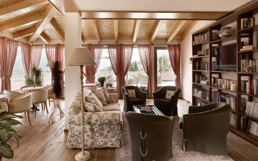 un soggiorno con divano e libreria di Hotel Garnì Carpe Diem a Vigo di Fassa