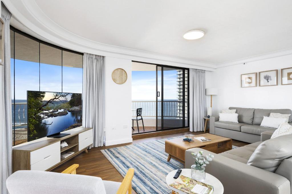uma sala de estar com um sofá e uma televisão em Aegean Apartments - Q Stay em Gold Coast