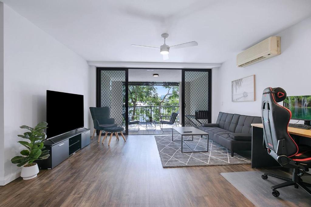 uma sala de estar com um sofá e uma televisão em Centro at Toowong - Modern Spacious Living with Pool em Brisbane