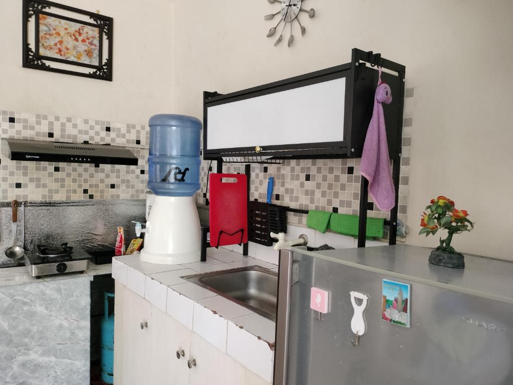 a kitchen with a sink and a tv on the wall at Eurich Furnished Unit 1 in Butuan