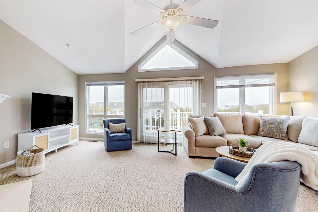 a living room with a couch and a tv at Villas of Beach Cove --- 29076 Beach Cove Square #D7 in Bayberry Dunes