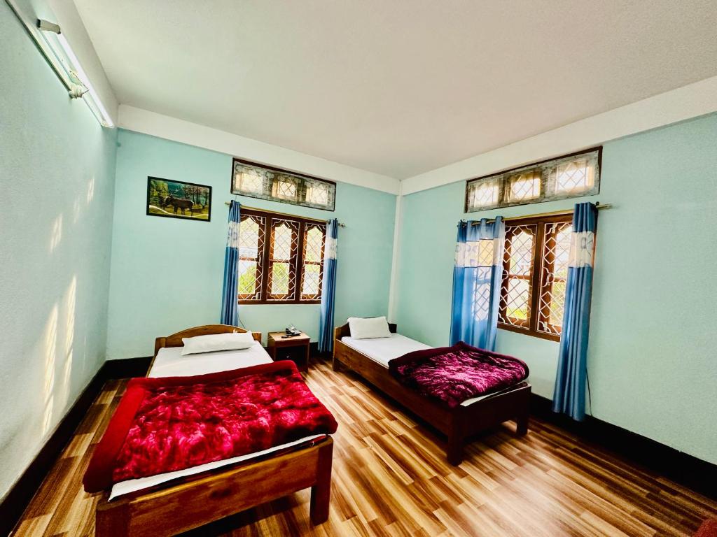 1 dormitorio con 2 camas y 2 ventanas en Pema Dekey monastic guest house, en Dirang Dzong