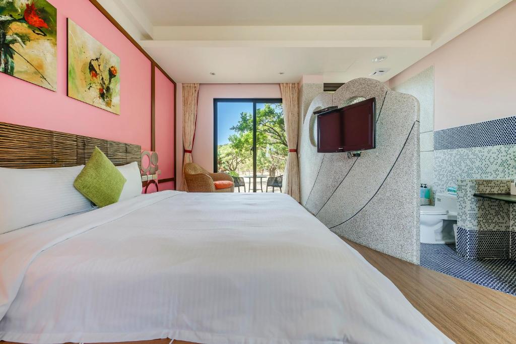 a bedroom with a large bed and a tv at Southern Sun Homestay North in Kenting