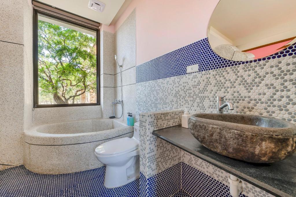 a bathroom with a sink and a tub and a toilet at Southern Sun Homestay North in Kenting
