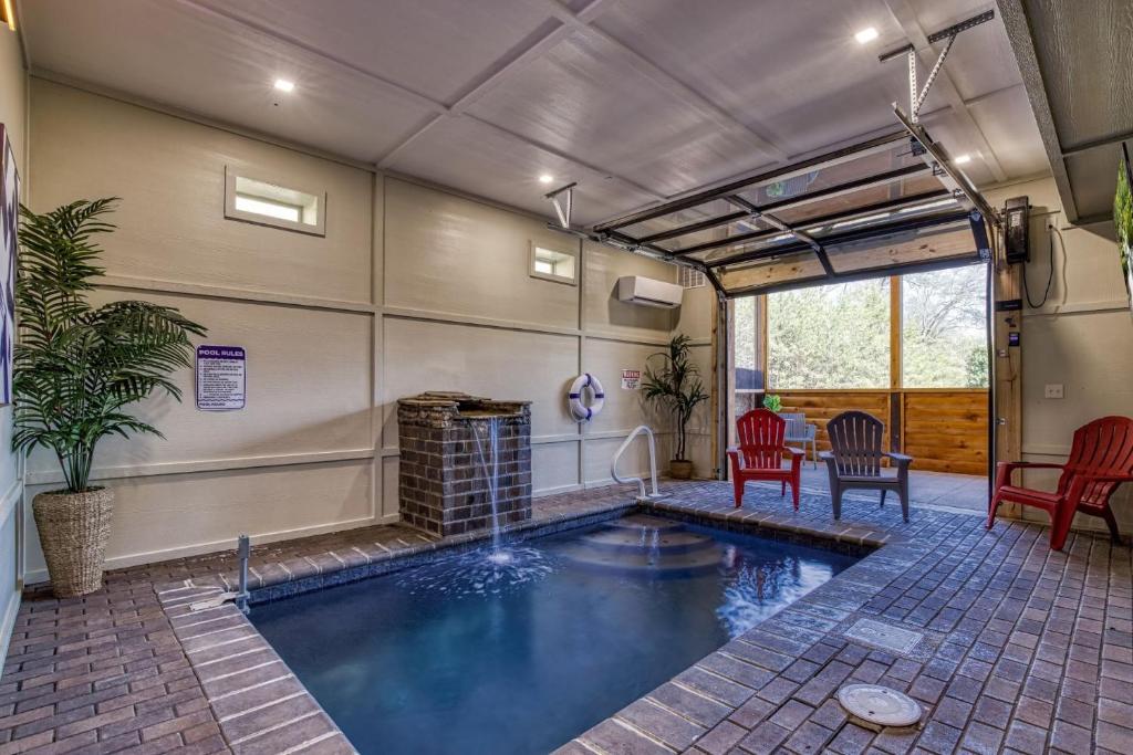 een zwembad in een kamer met stoelen en een tafel bij ER29 - Pop's Perch cabin in Pigeon Forge