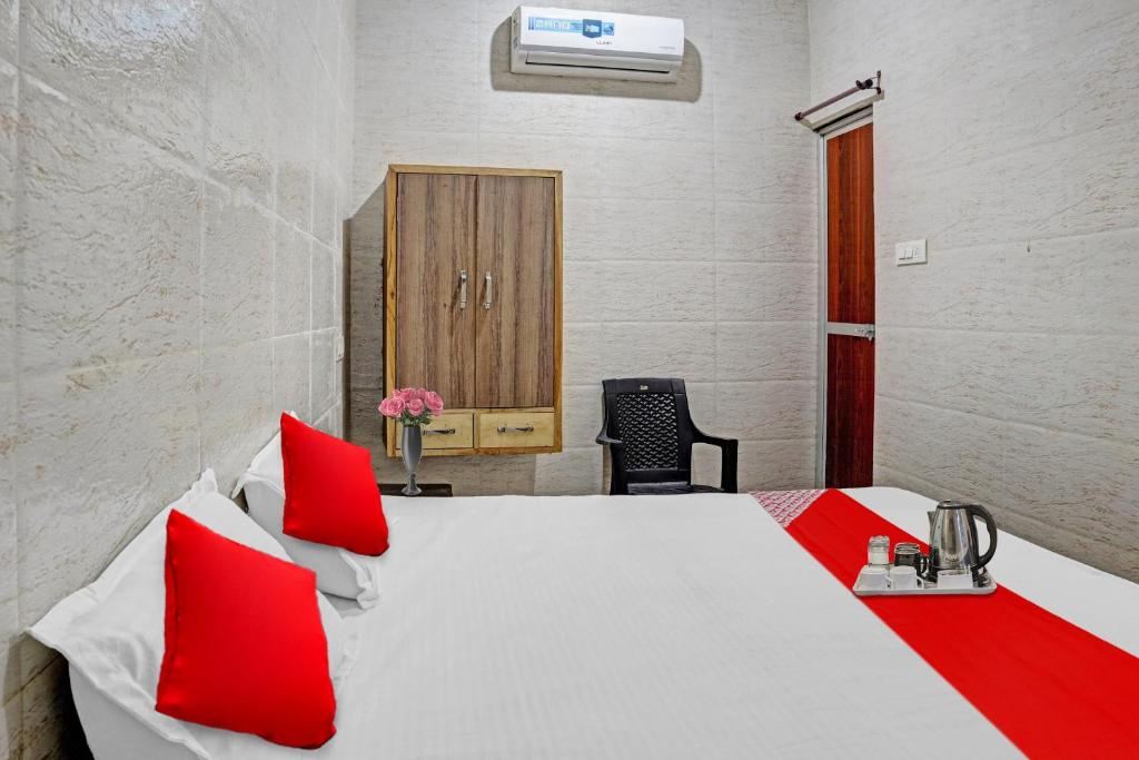 - une chambre avec un lit blanc et des oreillers rouges dans l'établissement Flagship New Mansi Hotel, à Bilāspur