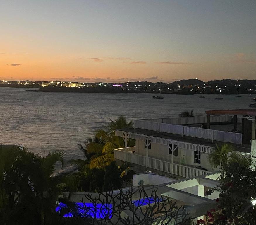 a view of the water at sunset from a building at Green Flash Apartments in Lance aux Épines