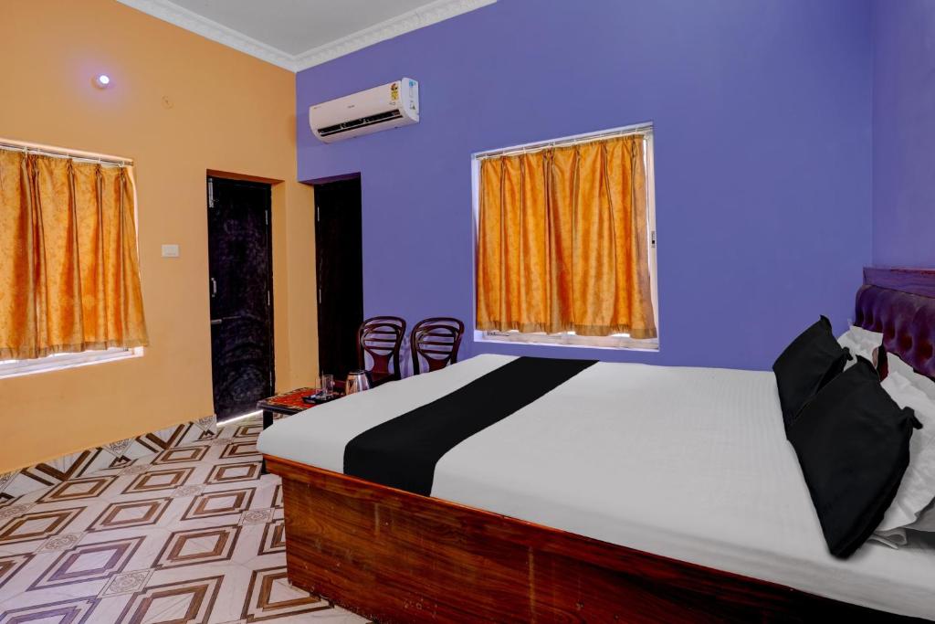 - une chambre avec un lit et 2 fenêtres avec des chaises dans l'établissement OYO Flagship HOTEL OM PALACE & BANQUET HALL, à Deoghar