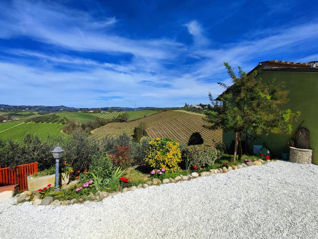 a garden in front of a house with a view of the hills at Tuscany Hills La Veduta in Certaldo