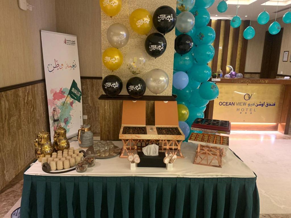 ジッダにあるOcean View Al Zahraのケーキと風船が乗ったテーブル
