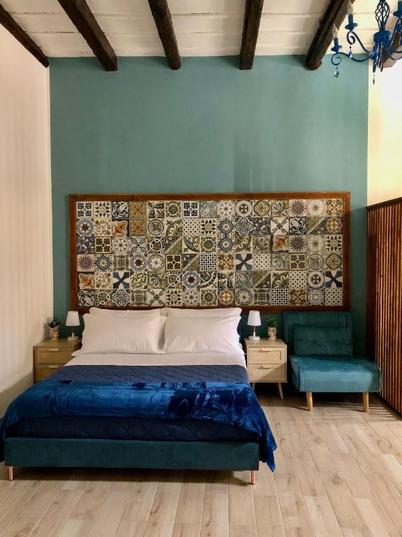 a bedroom with a bed and a blue wall at LA CASA DELL'EMIRO in Misilmeri