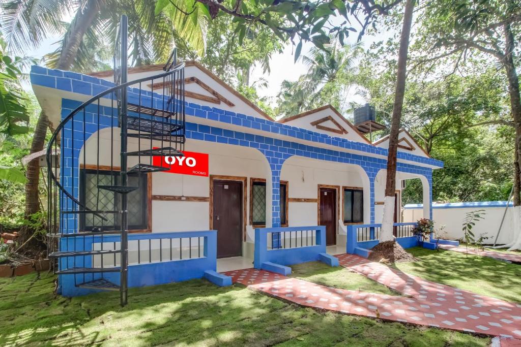 a house with a blue and white at OYO Grand Royals Anjuna Near Anjuna Beach in Anjuna