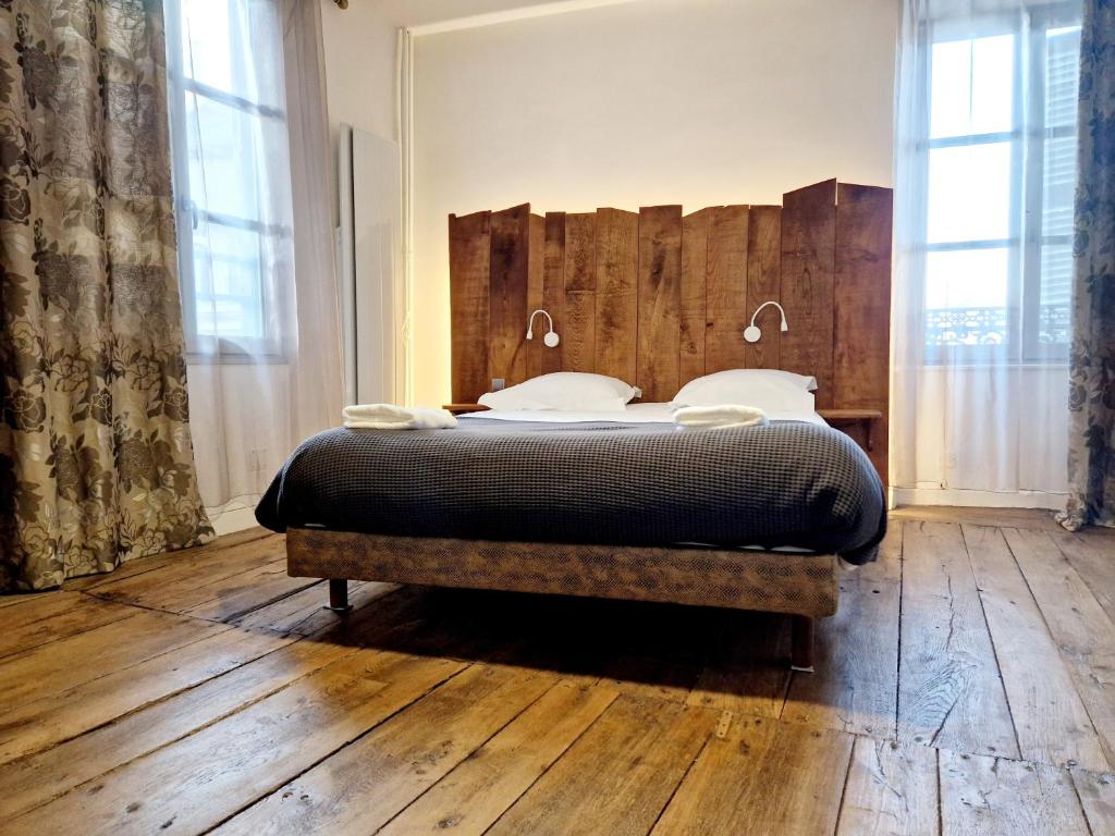 1 dormitorio con 1 cama con cabecero de madera en Au Pont Vieux, en Espalion