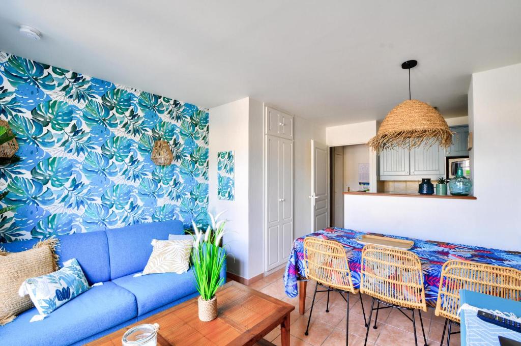 un salon avec un canapé bleu et une table dans l'établissement La résidence du Lac - maeva Home - Maison atypique 3 pièces 6 personnes - Prestige - super Home MAE-2884, à Monflanquin