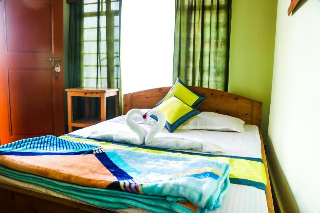 ein Schlafzimmer mit einem Bett mit Handtüchern darauf in der Unterkunft Choice Home Stay in Kalimpong