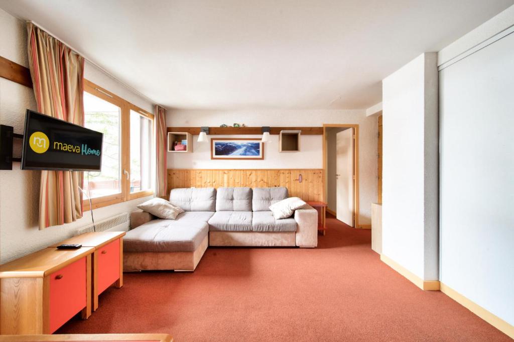 un salon avec un canapé et une télévision dans l'établissement Résidence Plagne Lauze - maeva Home - Appartement 3 pièces 6 personnes - Sélection MAE-2674, à Mâcot La Plagne