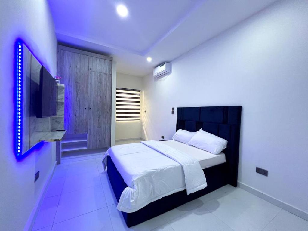 een slaapkamer met een groot bed en een televisie bij Honey homes in Lekki