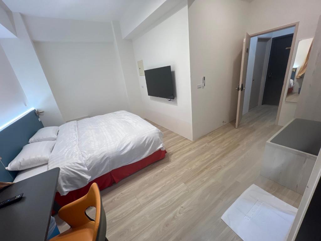 Dormitorio con cama, escritorio y TV en 111古坑行旅 