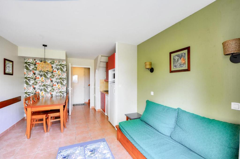 un salon avec un canapé bleu et une table dans l'établissement La résidence du Lac - maeva Home - Maison 3 pièces 6 personnes - Prestige MAE-3761, à Monflanquin
