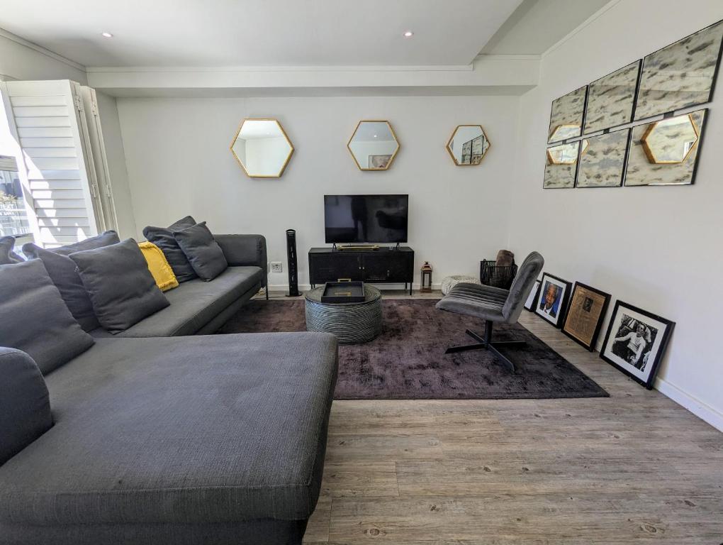 sala de estar con sofá y TV en Modern Retreat in District Six, en Ciudad del Cabo
