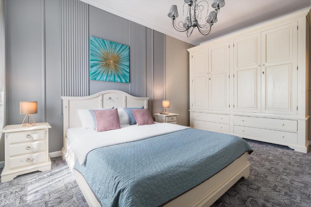 a bedroom with a bed and a chandelier at Moonlight Central Apartments in Oradea