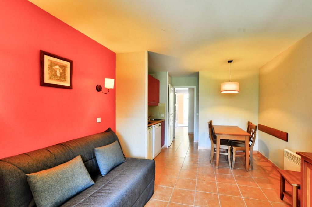 un salon avec un canapé et une table dans l'établissement La résidence du Lac - maeva Home - Appartement 2 pièces 4 personnes - Sélection MAE-1511, à Monflanquin
