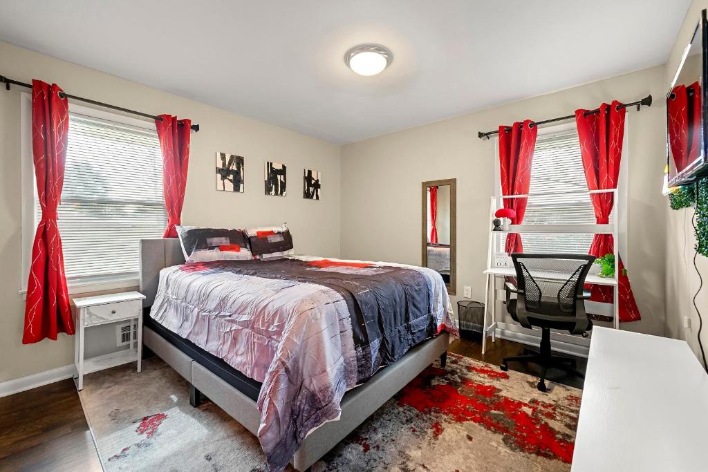 a bedroom with red curtains and a bed and a chair at Good Vibes @ Astroworld by MARTA/Downtown/Midtown/Hartsfield-Jackson Airport in Atlanta