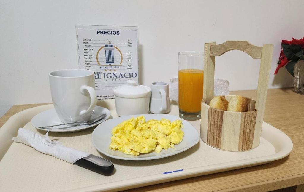 Chepén的住宿－Hotel Jose Ignacio Chepen，盘子上放着一盘炒鸡蛋和一杯橙汁