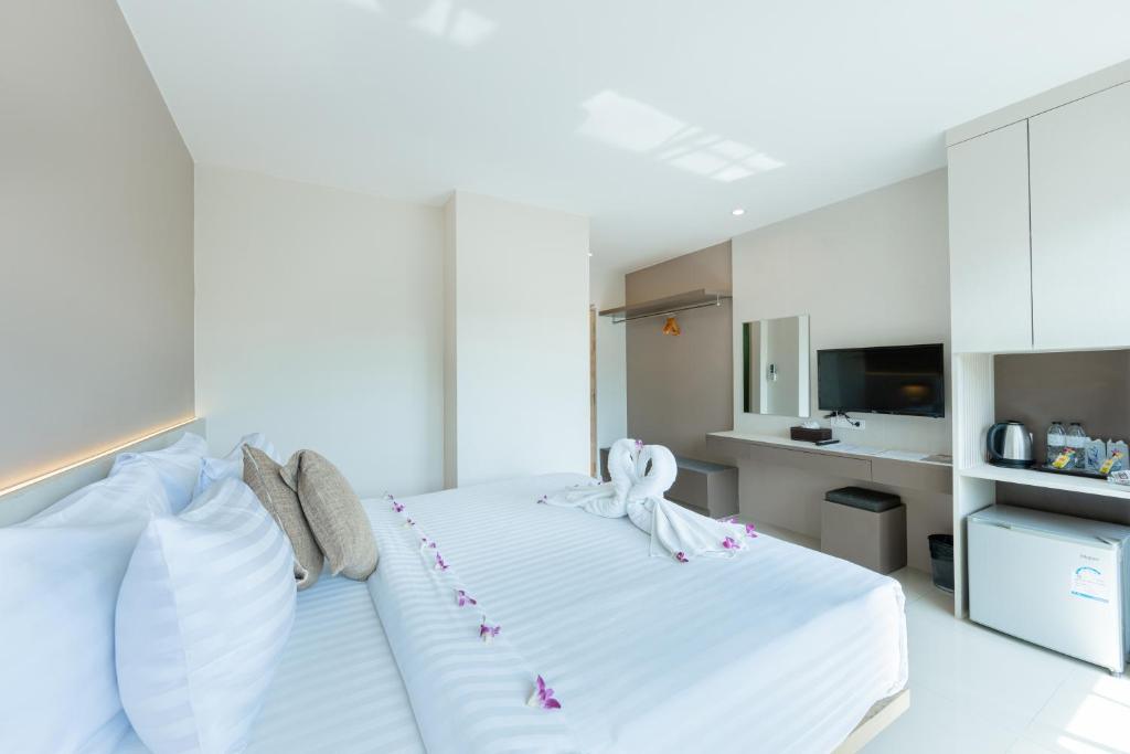 ein Schlafzimmer mit einem großen weißen Bett mit Blumen darauf in der Unterkunft La Vista Patong Hotel in Patong Beach
