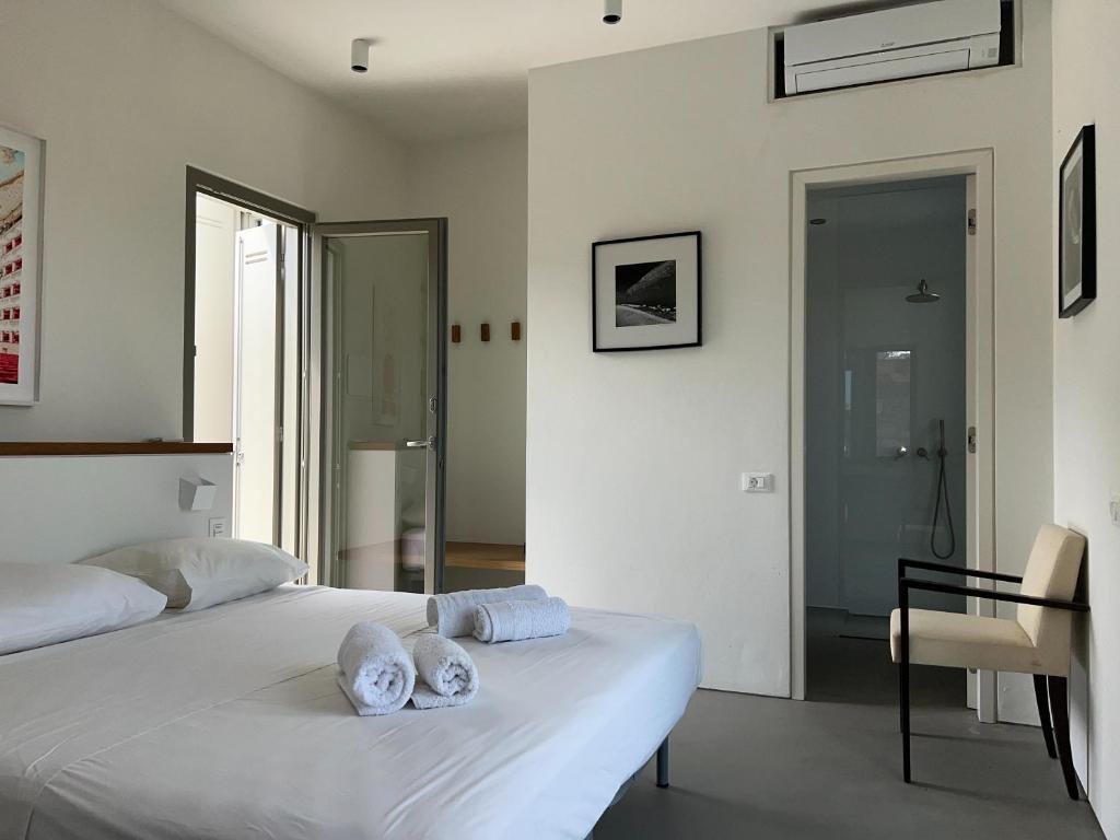 a bedroom with a white bed with towels on it at Villa Serene Milos in Empourios