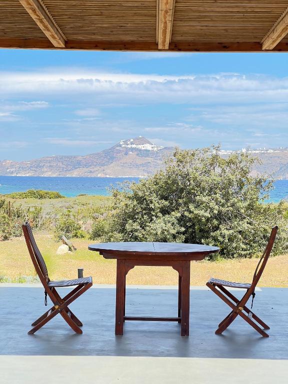 a table and two chairs with a view of the ocean at Villa Serene Milos in Empourios