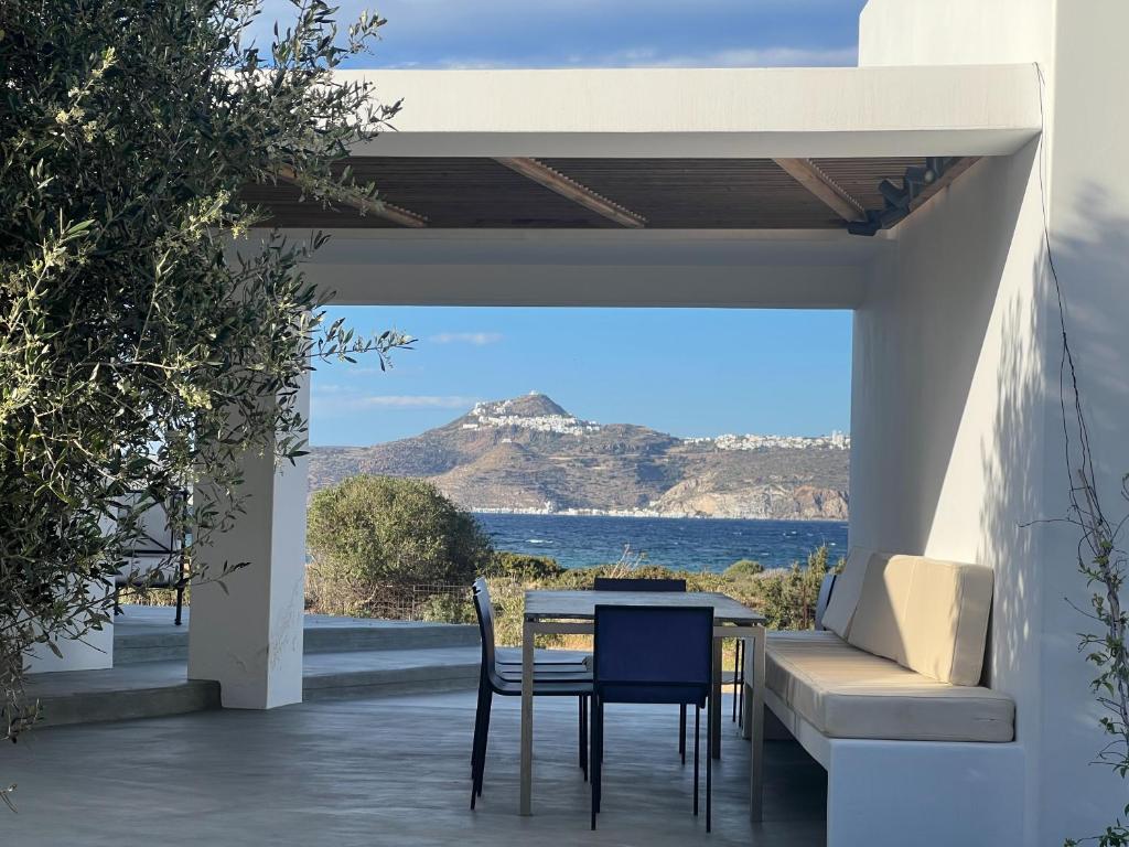 a table and chairs on a patio with a view of the ocean at Villa Serene Milos in Empourios