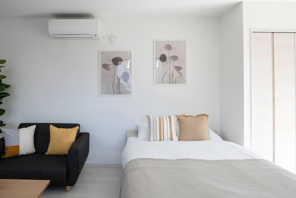 a white bedroom with a bed and a couch at NEW！　菊川駅徒歩1分｜浅草・秋葉原近辺｜銀座・築地・豊洲・新宿・渋谷アクセス良好　 in Tokyo