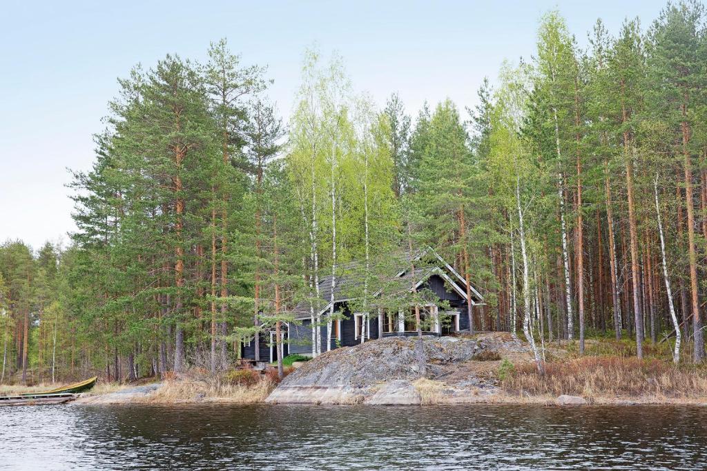 une cabine sur une île au milieu d'un lac dans l'établissement Mökki Aapola, à Puumala