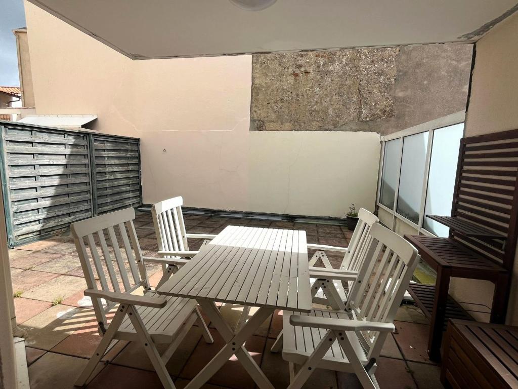 um pátio com uma mesa e cadeiras numa varanda em La Terrasse em Les Sables-dʼOlonne
